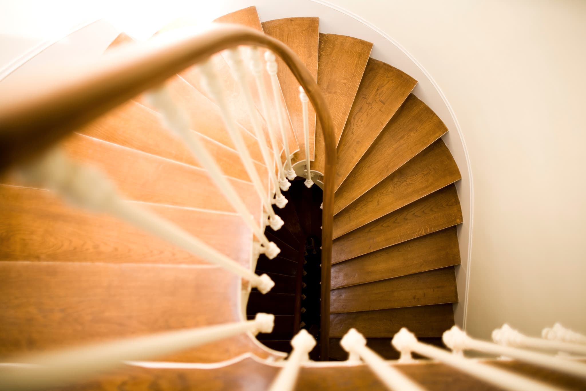 Escalier tournant en bois, vu depuis le palier supérieur.