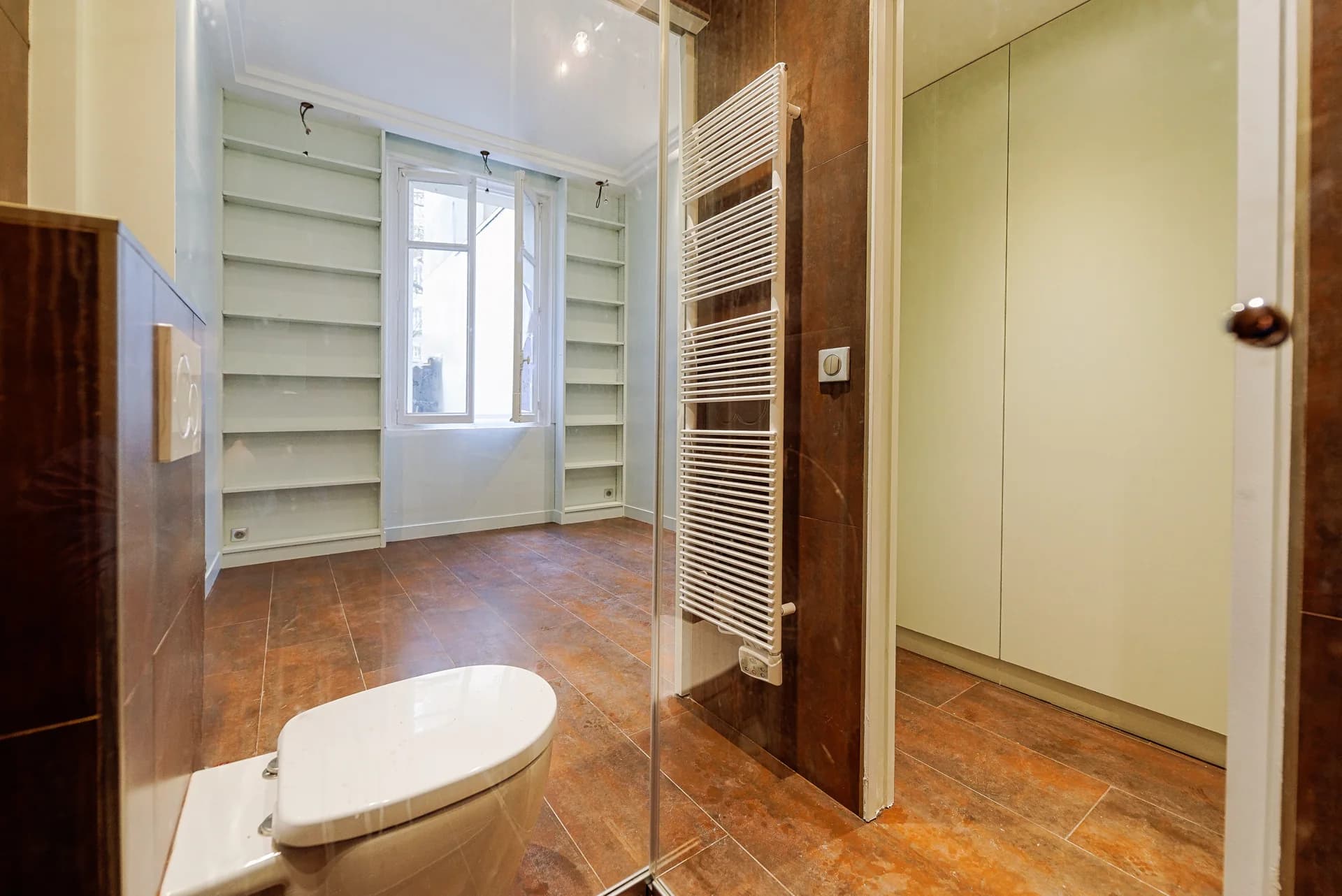 Salle d’eau et rangements intégrés autour d’une fenêtre.
